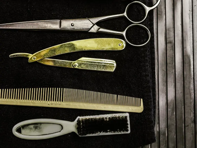 Scissors, razor and comb on a towel (example photo)