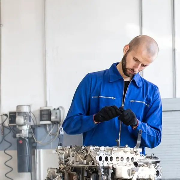Technician working on an engine (example photo)